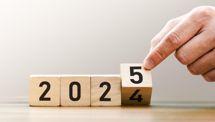 Transitioning from 2024 to 2025 with wooden blocks symbolizing target business for the upcoming year. This represents planning, investment, and innovation as ideas move from the end of 2024 new year